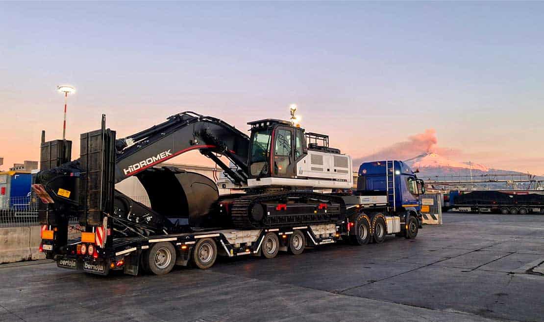 Trasporto pesante di escavatore su camion a lunga distanza, servizio specializzato di Dafo Trasporti.